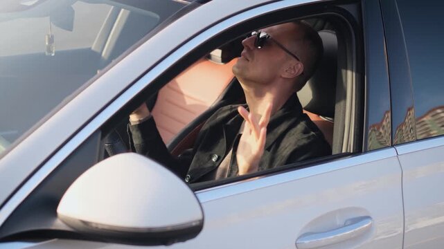 Happy adult man singing and moving while sitting behind the wheel of a car