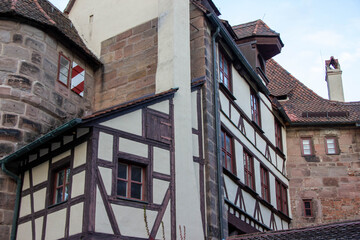 Historic building featuring traditional timber framing and stone walls, showcasing architectural details and textures, surrounded by a picturesque landscape with clear skies