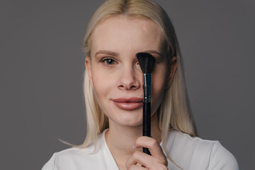 skilled makeup professional performing precise foundation application for natural look in neutral setting