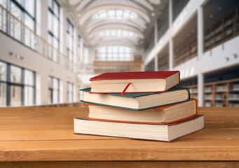 stack of school reading books on wooden table in library