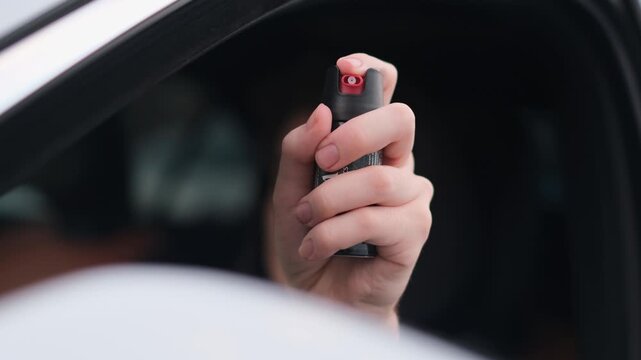 A male driver holds a canister of tear gas in his hands