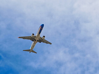A large jet plane is flying through a clear blue sky
