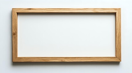Fototapeta premium Empty wooden picture frame with natural oak finish against white wall background, ready for artwork or photography display.