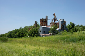 Afternoon sun shines on a rusting abandoned grain elevator near Emporia, Kansas, USA.