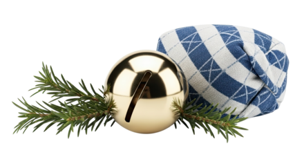 A shiny golden jingle bell ornament with a fresh evergreen sprig and a cozy blue argyle fabric creates a classic festive holiday composition isolated on a black background