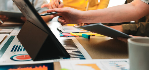 A dynamic business meeting scene showcasing collaboration over digital devices, complete with presentation charts and colorful notes, fostering innovation in a modern office. SACTR