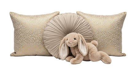 A cute beige plush bunny rabbit toy with long floppy ears rests against elegant decorative pillows with gold polka dots, isolated on a black background for a cozy nursery concept