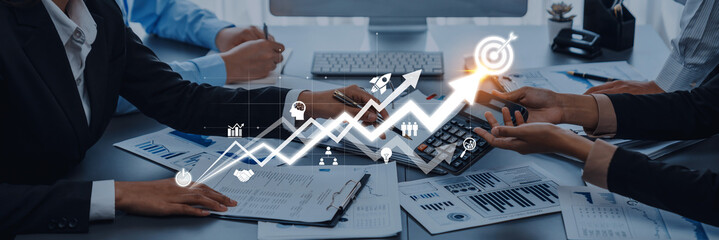 A dynamic business meeting scene showcasing hands engaged in discussion, financial charts displayed, symbolizing growth strategies and collaborative efforts in the workplace. Trope