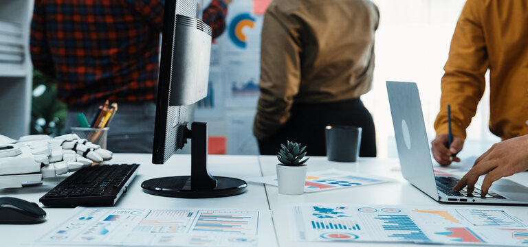 Engaging office scene showcasing a team discussing data analytics with laptops and charts, emphasizing collaboration, productivity, and innovative solutions in a modern workspace.Noogenesis - Powered by Adobe