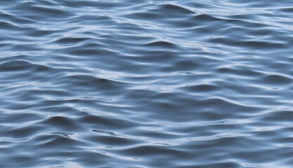 Soft waves on blue water surface, natural background