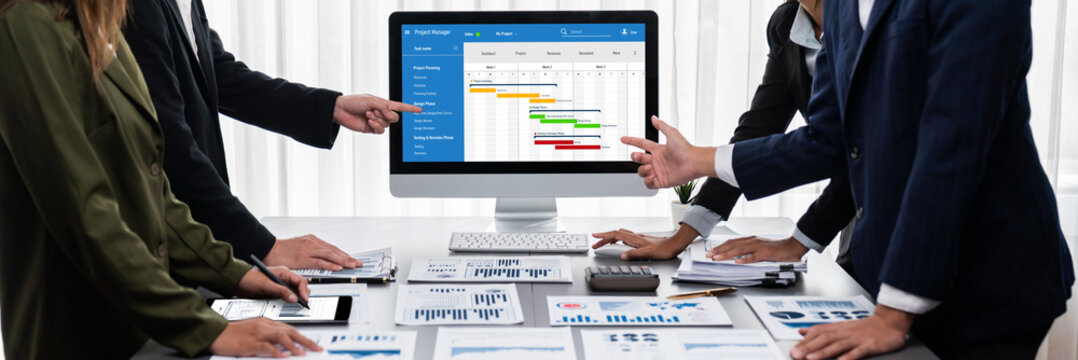 Panorama shot analyst team utilizing BI Fintech to analyze financial report with laptop. Businesspeople analyzing BI data dashboard displayed on laptop screen for business insight. Prodigy