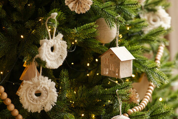 Beautiful decorated Christmas tree closeup, toys in Scandinavian style. Modern new year decorations...