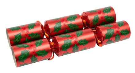 Two red Christmas crackers with a festive holly and berry pattern, tied with orange ribbons, are arranged diagonally on an isolated black background for a holiday celebration