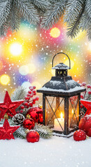 Lantern with candle siting in the snow surrounded by festive red Christmas ornaments