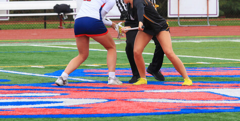 Two Players Compete for the Ball During a Lacrosse Faceoff