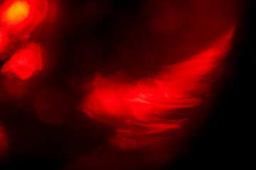 Red color light leaks on dark background for design and special effects.