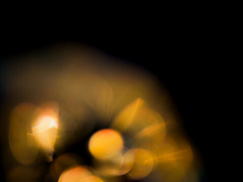 Colorful warm yellow light leaks on black background for design and special effects. Abstract lens flare.