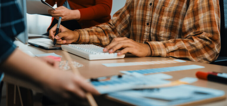 A dynamic creative office scene showcasing teamwork and collaboration. Hands engaged with a computer and paperwork highlight the essence of modern business creativity. SACTR - Powered by Adobe