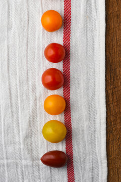 Flat lay still life of a variety of chery tomatoes on a kitchen towel.