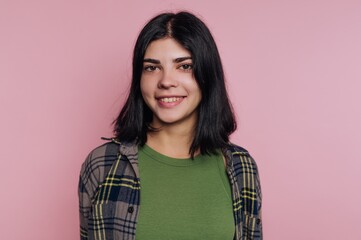Fototapeta premium portrait of confident young woman's showcases her charm and style, with a plaid shirt on pink background