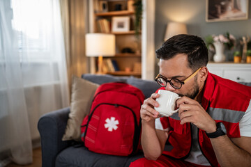 Paramedic man relaxing at home, enjoying coffee break