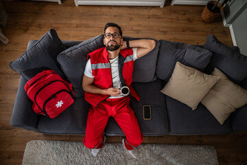Paramedic taking coffee break resting on couch