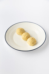 Three potato dumplings on a plate, studio shot on white background