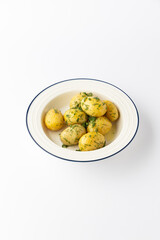Boiled baby potatoes with butter and fresh dill in bowl, isolated on white background