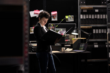 Law enforcement agent making connections between clues and confidential files, tracing clues with...