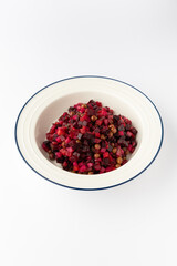 Vinaigrette salad with beetroot, potato, carrot and peas, diced and dressed, isolated on white