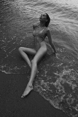 Fototapeta premium Girl lying on the sandy beach. ocean wayves and summer vibe 