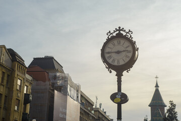 November 16, 2025 - Timisoara, Romania. An old-fashioned clock in the square. The numbers are Roman and the hands show fifteen minutes to three.