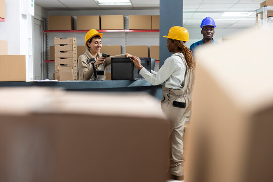 Industrial depot operations managed by diverse staff using scanners to register goods for distribution. Boxes and products ready for shipment, supported by strong supply chain systems.