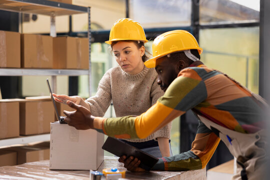 Worker preparing pallets and cardboard boxes in a shipping facility, supporting small business e-commerce with timely delivery, storage management and product handling services.