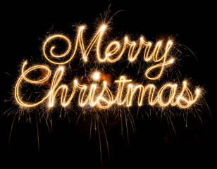 Luminous Merry Christmas Greeting Written in Golden Sparkler Calligraphy Against a Black Night.