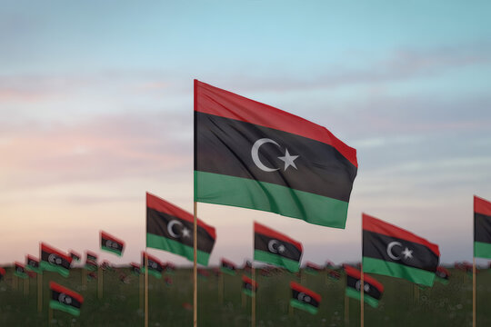 Field of Libyan flags waving gently in the breeze against a pastel sky, evoking patriotism and national pride on display