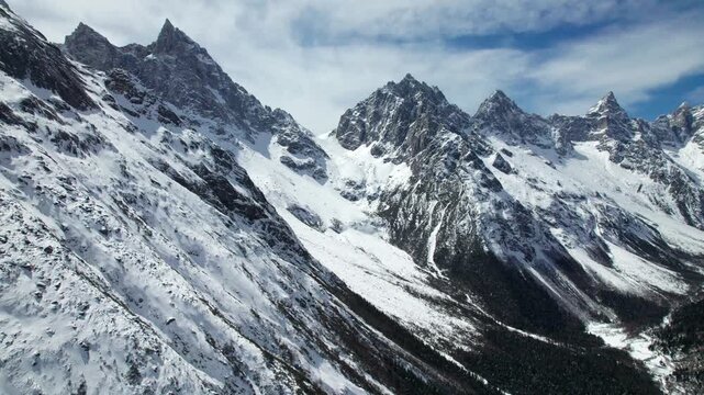 Drone view of snow covered mountains and forests in Bipeng Valley in Sichuan, China in sunny winter day, high angle view of beautiful winter landscape. 4k real time footage, travel concept
