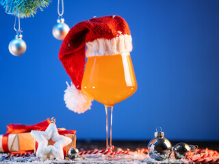 New Year's beer glass on a blue background. Gift boxes and balls on a table with snow.