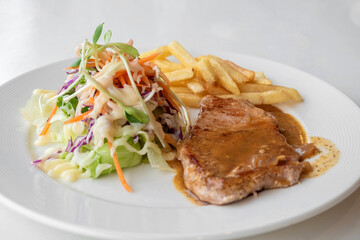 Close up of Grilled pork steak, boiled french fries and vegetable salad;Selective focus
