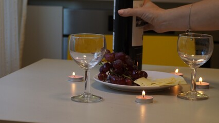 Romantic couple enjoying dinner at home, concept love, relationship and romantic, happy couple celebrating and making cheers with glasses of red wine. girl eats grapes and cheese, Valentine's Day
