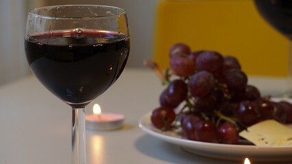 Romantic couple enjoying dinner at home, concept love, relationship and romantic, happy couple celebrating and making cheers with glasses of red wine. girl eats grapes and cheese, Valentine's Day
