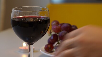 Romantic couple enjoying dinner at home, concept love, relationship and romantic, happy couple celebrating and making cheers with glasses of red wine. girl eats grapes and cheese, Valentine's Day
