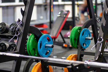 A row of weightlifting equipment in a gym with people in the background