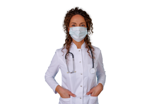 Female doctor wearing protective face mask and stethoscope, standing with hands in pockets, looking at camera
