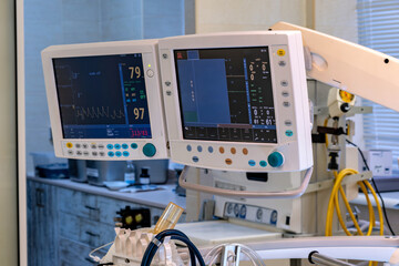 A hospital room with two monitors on the wall