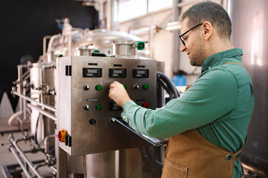 Man working on control panel in modern brewery