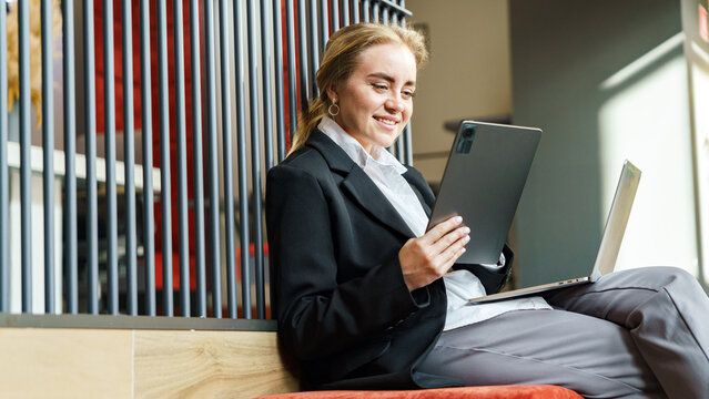 Young professional using tablet and laptop in modern office