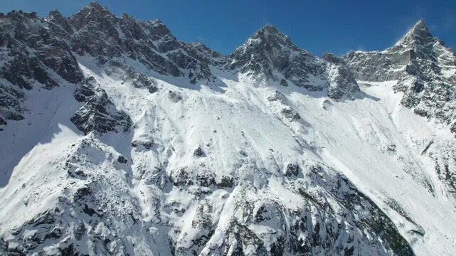 Drone view of snow covered mountains and forests in Bipeng Valley in Sichuan, China in sunny winter day, high angle view of beautiful winter landscape. 4k real time footage, travel concept
