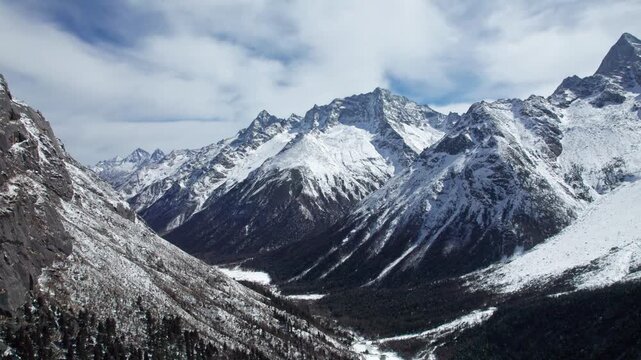 Drone view of snow covered mountains and forests in Bipeng Valley in Sichuan, China in sunny winter day, high angle view of beautiful winter landscape. 4k real time footage, travel concept