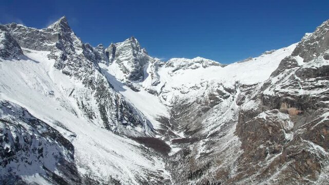 Drone view of snow covered mountains and forests in Bipeng Valley in Sichuan, China in sunny winter day, high angle view of beautiful winter landscape. 4k real time footage, travel concept